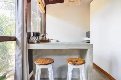 a kitchen with a counter with two stools at La Buena vida Cabina 4 in Playa Grande