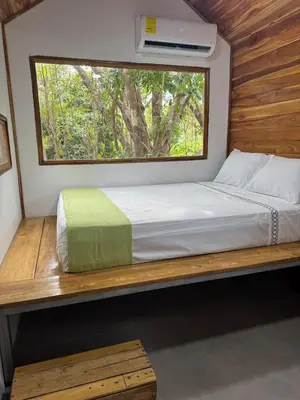 a bed in a small room with a window at Tiny House Surf Nature and Relaxation in Playa Negra