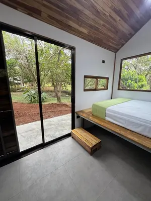 a bedroom with a bed and a large window at Tiny House Surf Nature and Relaxation in Playa Negra