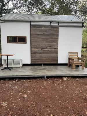 a small cabin with a table and a bench at Tiny House Surf Nature and Relaxation in Playa Negra