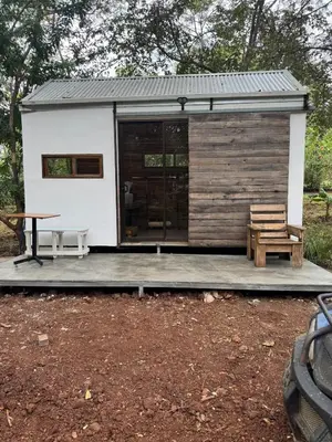 a tiny house with a porch and a picnic table at Tiny House Surf Nature and Relaxation in Playa Negra