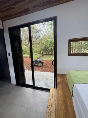 a bedroom with a bed and a sliding glass door at Tiny House Surf Nature and Relaxation in Playa Negra