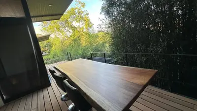 a wooden table on a deck with chairs at Bamboo grove villa in San Isidro