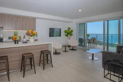 a kitchen and living room with a view at Panoramic ocean view condo-pools-gym-fast internet in Jacó