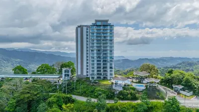 a tall building in the middle of a city at Panoramic ocean view condo-pools-gym-fast internet in Jacó