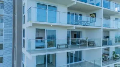 an apartment building with glass balconies and tables at Panoramic ocean view condo-pools-gym-fast internet in Jacó