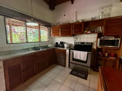 a kitchen with wooden cabinets and a stove top oven at Cantarrana Countryside Villa with private pool