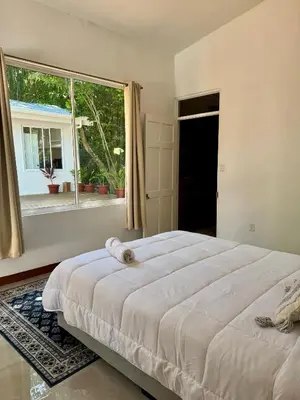 a bedroom with a large bed and a window at Villa Republik in Parrita