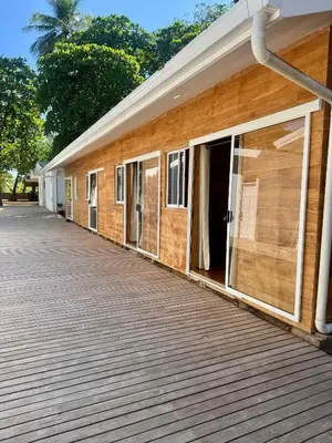 a building with a wooden deck next to it at Villa Republik in Parrita