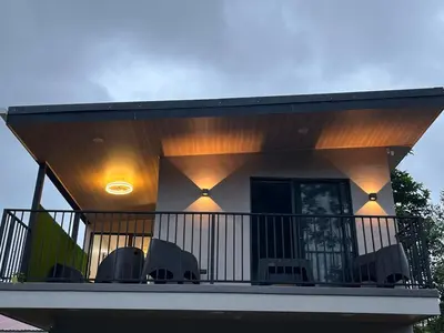 a house with a balcony with chairs on it at Villa Esencia La Fortuna in Fortuna