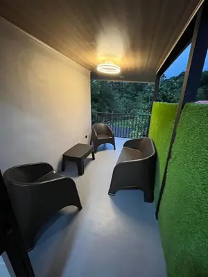 a room with chairs and a balcony with a view at Villa Esencia La Fortuna in Fortuna