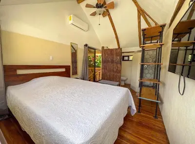 a bedroom with a white bed and a ladder at Silencio Verde in Atenas