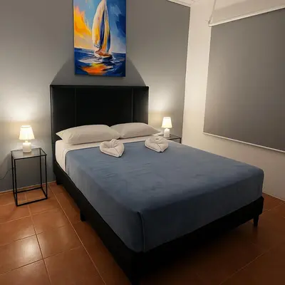 a bedroom with a large bed with two towels on it at PURA VIDA AIRPORT STAY FREE SHUTTLe in Alajuela City