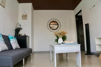 a living room with a couch and a table at PURA VIDA AIRPORT STAY FREE SHUTTLe in Alajuela City