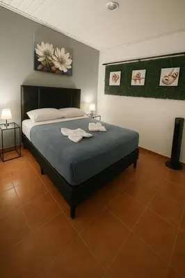 a bedroom with a bed with two towels on it at PURA VIDA AIRPORT STAY FREE SHUTTLe in Alajuela City