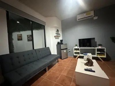 a living room with a couch and a tv at PURA VIDA AIRPORT STAY FREE SHUTTLe in Alajuela City