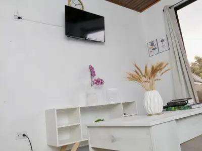 a white desk with a tv on a white wall at PURA VIDA AIRPORT STAY FREE SHUTTLe in Alajuela City