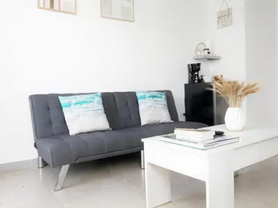 a living room with a couch and a white table at PURA VIDA AIRPORT STAY FREE SHUTTLe in Alajuela City