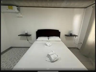 a bed in a room with two towels on it at PURA VIDA AIRPORT STAY FREE SHUTTLe in Alajuela City