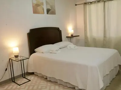 a bedroom with a bed with two towels on it at PURA VIDA AIRPORT STAY FREE SHUTTLe in Alajuela City