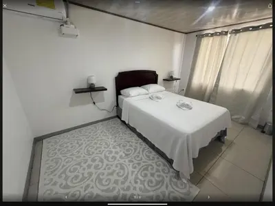 a bedroom with a white bed and a white floor at PURA VIDA AIRPORT STAY FREE SHUTTLe in Alajuela City