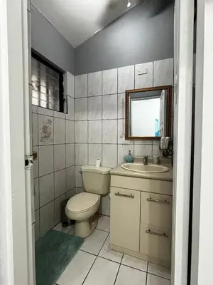 a bathroom with a toilet and a sink and a mirror at Punta Leona, Sotavento 1 Plea Mar casita in Punta Leona