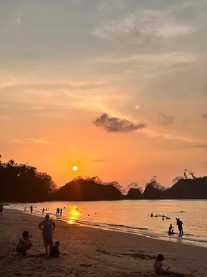 a group of people on the beach at sunset at Hospedaje el Argentico in Tapantí