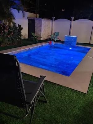 a swimming pool at night with a chair and a chair at Casa Tribu in Agujas