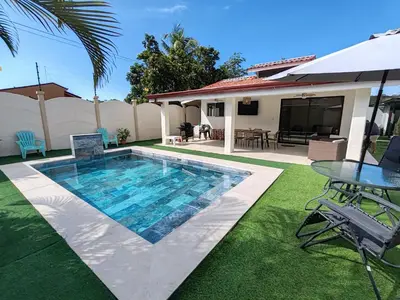 a swimming pool with a table and a house at Casa Tribu in Agujas
