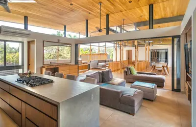 a kitchen and living room with a couch and a table at Nimbu East in Tamarindo