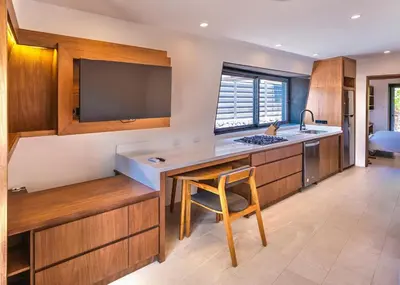 a kitchen with a sink and a counter with a chair at Nimbu East in Tamarindo
