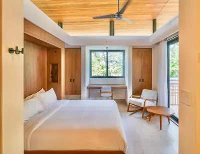 a bedroom with a large white bed and a window at Nimbu East in Tamarindo