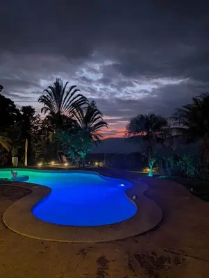 a swimming pool with blue water at night at 3BR, Spectacular Jungle Villa w Waterfalls & Toucans in Barú