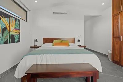 a bedroom with a bed and a painting on the wall at Villa Costa Sota - Ocean View & Pickleball Courts in Coco