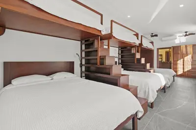 a bedroom with three beds and a stair case at Villa Costa Sota - Ocean View & Pickleball Courts in Coco