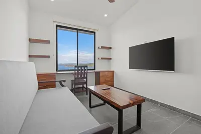 a living room with a couch and a flat screen tv at Villa Costa Sota - Ocean View & Pickleball Courts in Coco