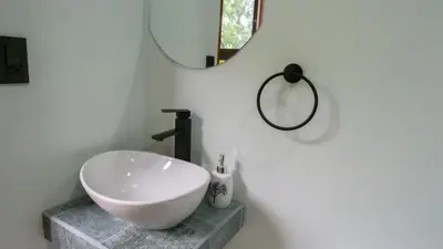a bathroom with a bowl sink and a mirror at Divan Jungle Lodge in Fortuna