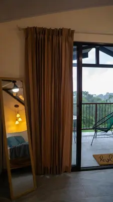 a bedroom with a mirror and a bed and a balcony at Divan Jungle Lodge in Fortuna