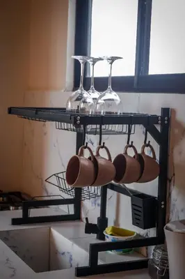 a rack with wine bottles and wine glasses on it at Divan Jungle Lodge in Fortuna