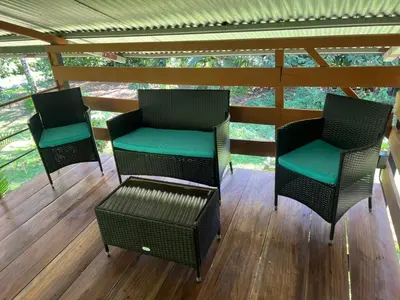 three chairs and a table on a porch at Cabañita tipo Chalet in Fortuna