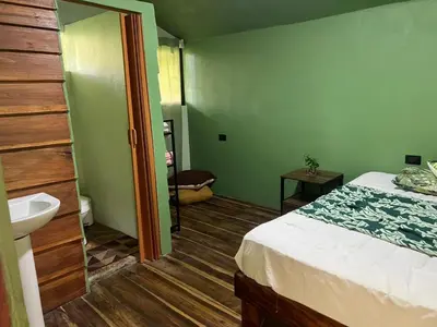 a bathroom with a bed and a sink in a room at Cabañita tipo Chalet in Fortuna