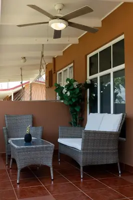 a porch with chairs and a table and a ceiling fan at Jacó Cozy 1BR Pool AC Secure Near Beach in Jacó