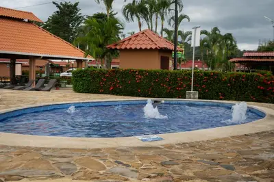 a pool with two water fountains in a courtyard at Jacó Cozy 1BR Pool AC Secure Near Beach in Jacó