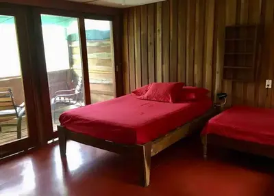 a bedroom with a red bed and a balcony at Casa Passiflora - Playa Grande in Refundores