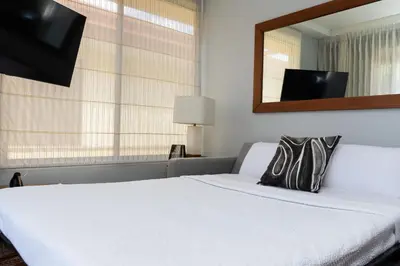 a bedroom with a white bed and a mirror at Corteza 2BD Gated AC Quiet Terrace Pools in Jacó