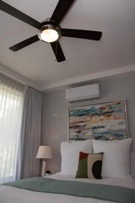 a bedroom with a ceiling fan and a bed at Corteza 2BD Gated AC Quiet Terrace Pools in Jacó