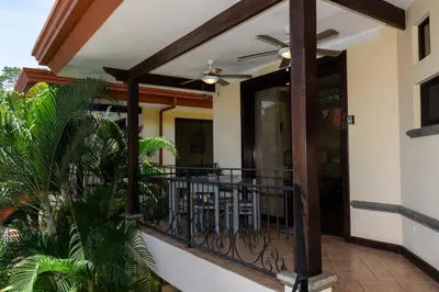 a house with a balcony with a ceiling fan at Corteza 2BD Gated AC Quiet Terrace Pools in Jacó