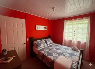 a bedroom with red walls and a bed and a window at Casas de Playa en Familia