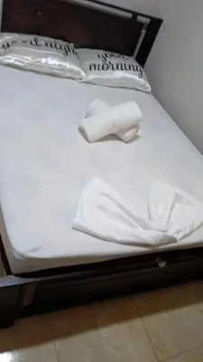 a bed with white sheets and towels on it at Casas de Playa en Familia
