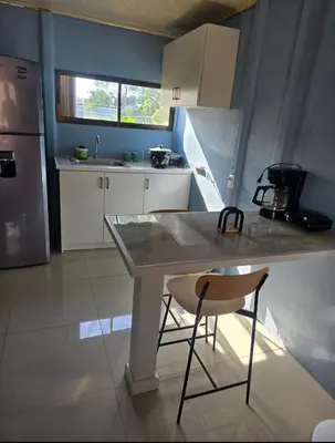 a kitchen with a table and a chair in it at Apartamento DesCANsO #2 in Comunidad